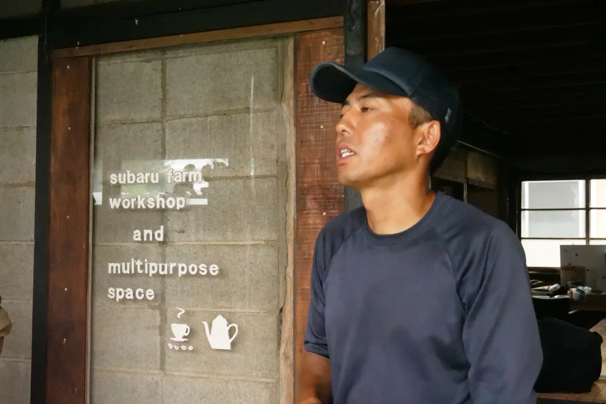 帽子をかぶって作業場で話すスタッフの表情